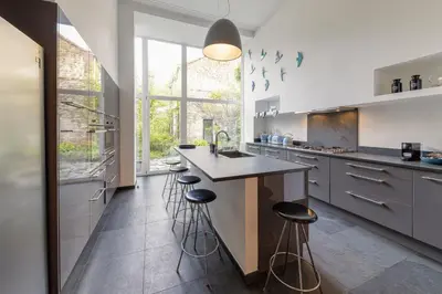 a kitchen with a counter and stools in it at Atelier K - Art Guesthouse in Brussels in Brussels