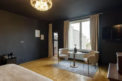 a bedroom with a bed and a table and chairs at Atelier K - Art Guesthouse in Brussels in Brussels