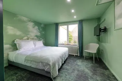 a green bedroom with a bed and a window at Atelier K - Art Guesthouse in Brussels in Brussels