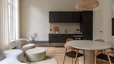 a living room with a white table and chairs at De Gulden Poorte, a LXRYHOME Hotel Collection in Antwerp