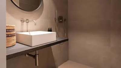 a bathroom with a white sink and a mirror at De Gulden Poorte, a LXRYHOME Hotel Collection in Antwerp