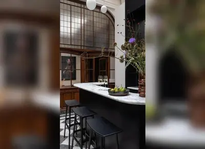 a kitchen with a counter with stools and a bar at De Gulden Poorte, a LXRYHOME Hotel Collection in Antwerp