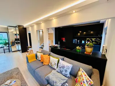 a living room with a gray couch with pillows at Town house with garden - 1 room with shared bathroom in Brussels