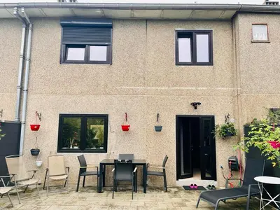 a patio with a table and chairs in front of a building at Town house with garden - 1 room with shared bathroom in Brussels
