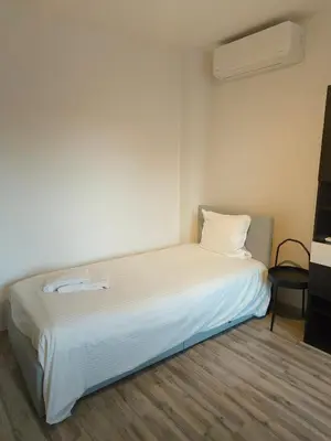 a white bed in a room with a white wall at Lichtrijke woning vlakbij Leuven in Herent
