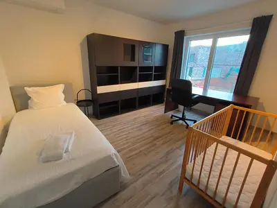 a hotel room with a bed and a desk and a computer at Lichtrijke woning vlakbij Leuven in Herent