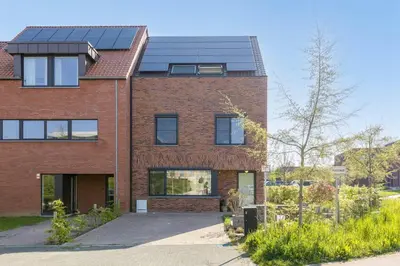 a red brick house with solar panels on it at Lichtrijke woning vlakbij Leuven in Herent
