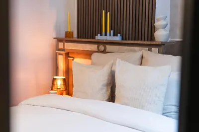 a bedroom with a bed with white sheets and pillows at Spacious Shared 5BR Apt in the Heart of Gent in Ghent