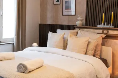 a bedroom with a large bed with white sheets and pillows at Spacious Shared 5BR Apt in the Heart of Gent in Ghent