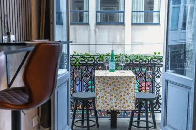 a table with two chairs and a bottle on it on a balcony at Spacious Shared 5BR Apt in the Heart of Gent in Ghent