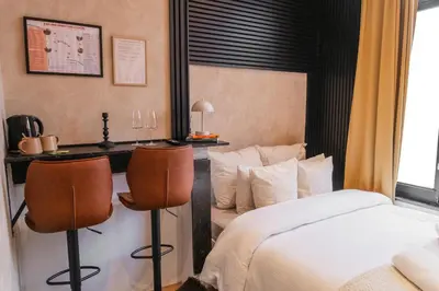 a hotel room with a bed and two chairs at Spacious Shared 5BR Apt in the Heart of Gent in Ghent