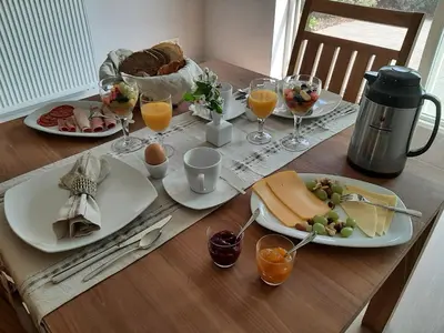 a table with plates of food and glasses of orange juice at B&B De Levensboom in Tessenderlo