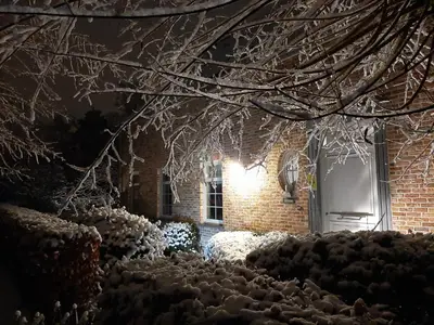 a house with snow covered branches and a door at B&B De Levensboom in Tessenderlo