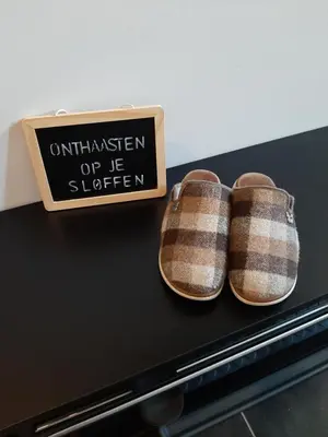 a pair of shoes sitting on a table with a sign at B&B De Levensboom in Tessenderlo