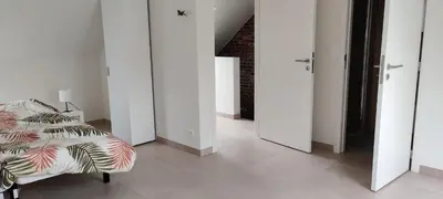 a room with a bed and a hallway with white doors at Docs House in Wetteren