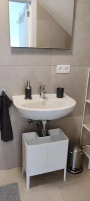 a bathroom with a white sink and a mirror at Docs House in Wetteren