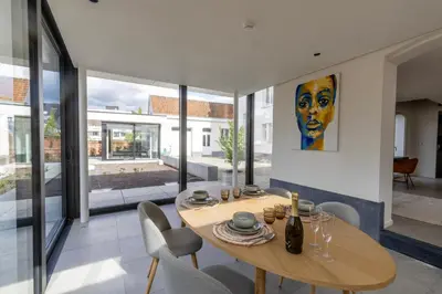 a dining room with a wooden table and chairs at Zeer unieke vakantiewoning in Herentals