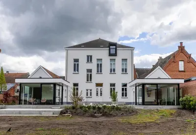 a large white house with glass doors and windows at Zeer unieke vakantiewoning in Herentals