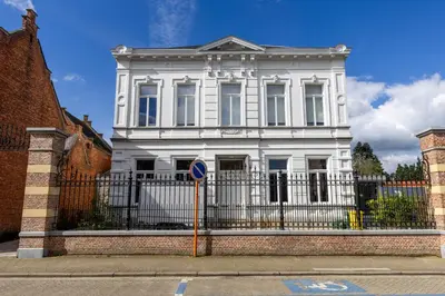 a white house with a fence in front of it at Zeer unieke vakantiewoning in Herentals