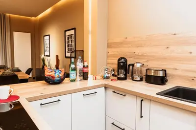 a kitchen with white cabinets and a counter top at Golden Dove Luxury Apartment in Brussels
