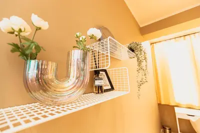 a shelf with a vase and flowers on it at Golden Dove Luxury Apartment in Brussels