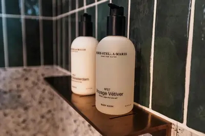 three bottles of sunscreen sitting on a shelf in a bathroom at Golden Dove Luxury Apartment in Brussels