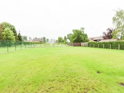 a large grassy field with a fence at Glabbeek Family Retreat Home in Bunsbeek