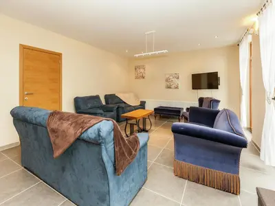 a living room with two couches and a tv at Glabbeek Family Retreat Home in Bunsbeek