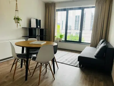 a living room with a table and chairs and a couch at Jardin Botanique in Brussels