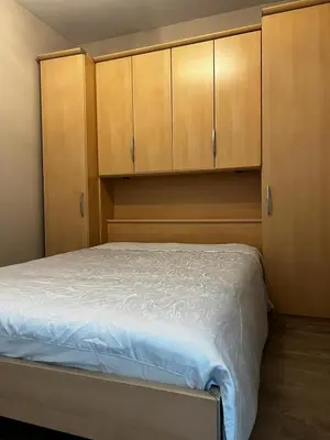 a bedroom with a bed and wooden cabinets at Jardin Botanique in Brussels