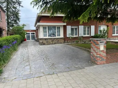a brick house with a driveway in front of it at Cosy in Mechelen