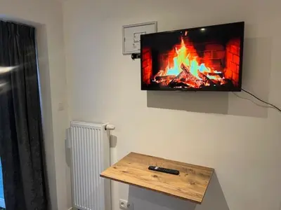 a tv hanging on a wall with a fireplace at Cosy in Mechelen