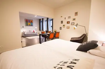 a bedroom with two beds and a living room at Getaway Leuven in Leuven