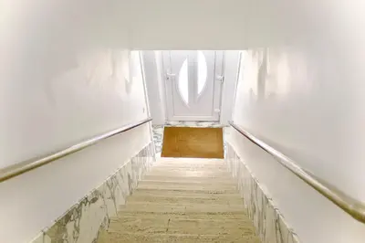 a hallway with a white door and a staircase at Chez Nadège in Affligem