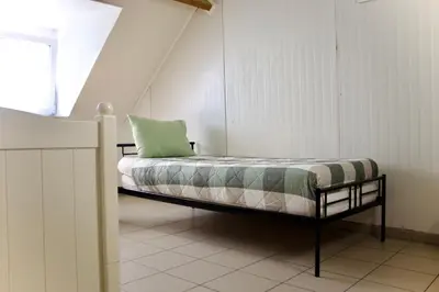 a bedroom with a bed with a green pillow on it at Chez Nadège in Affligem