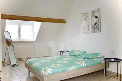 a bedroom with a bed and two tables at Chez Nadège in Affligem