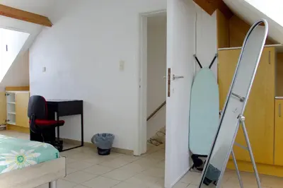 a room with a surfboard leaning against a wall at Chez Nadège in Affligem
