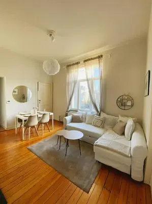 a living room with a white couch and a table at Cute central flat in Brussels in Brussels