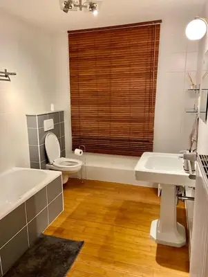 a bathroom with two sinks and a toilet and a window at Cute central flat in Brussels in Brussels