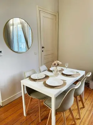 a white dining room table with chairs and a mirror at Cute central flat in Brussels in Brussels