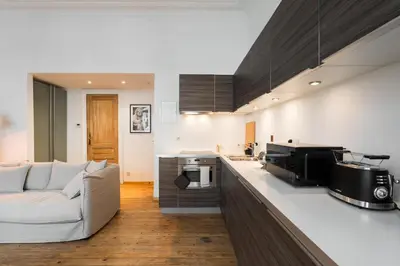 a kitchen and living room with a couch and a counter at The American Loft in Brussels