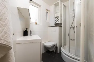 a white bathroom with a toilet and a sink at The American Loft in Brussels