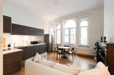 a kitchen and living room with a couch and a table at The American Loft in Brussels