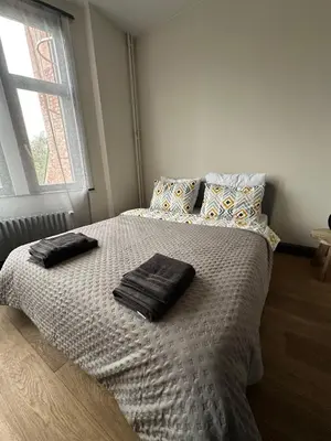 a bedroom with a bed with two towels on it at Ces Home Centrum in Ghent
