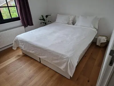 a bed with white sheets and pillows in a bedroom at Villa Tibur - Near Boom & Rumst in Rumst