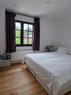 a bedroom with a white bed and a window at Villa Tibur - Near Boom & Rumst in Rumst