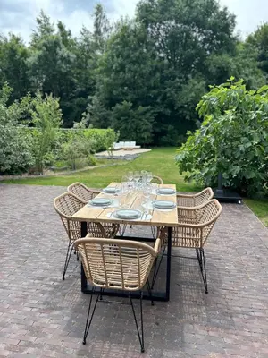 a table with chairs and plates and wine glasses at Villa Tibur - Near Boom & Rumst in Rumst
