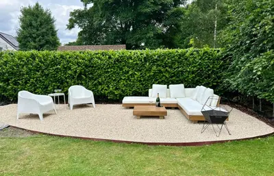 a patio with a white couch and chairs in a yard at Villa Tibur - Near Boom & Rumst in Rumst