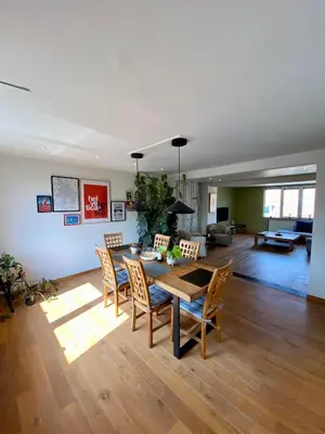 a living room with a dining room table and chairs at Stijlvolle duplex nabij Brussel en luchthaven! in Meise