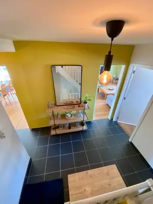 a living room with a large mirror on a yellow wall at Stijlvolle duplex nabij Brussel en luchthaven! in Meise